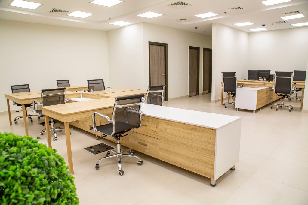 A bright, open-plan commercial office workspace featuring custom timber workstations and storage units completed via professional joinery designer services.