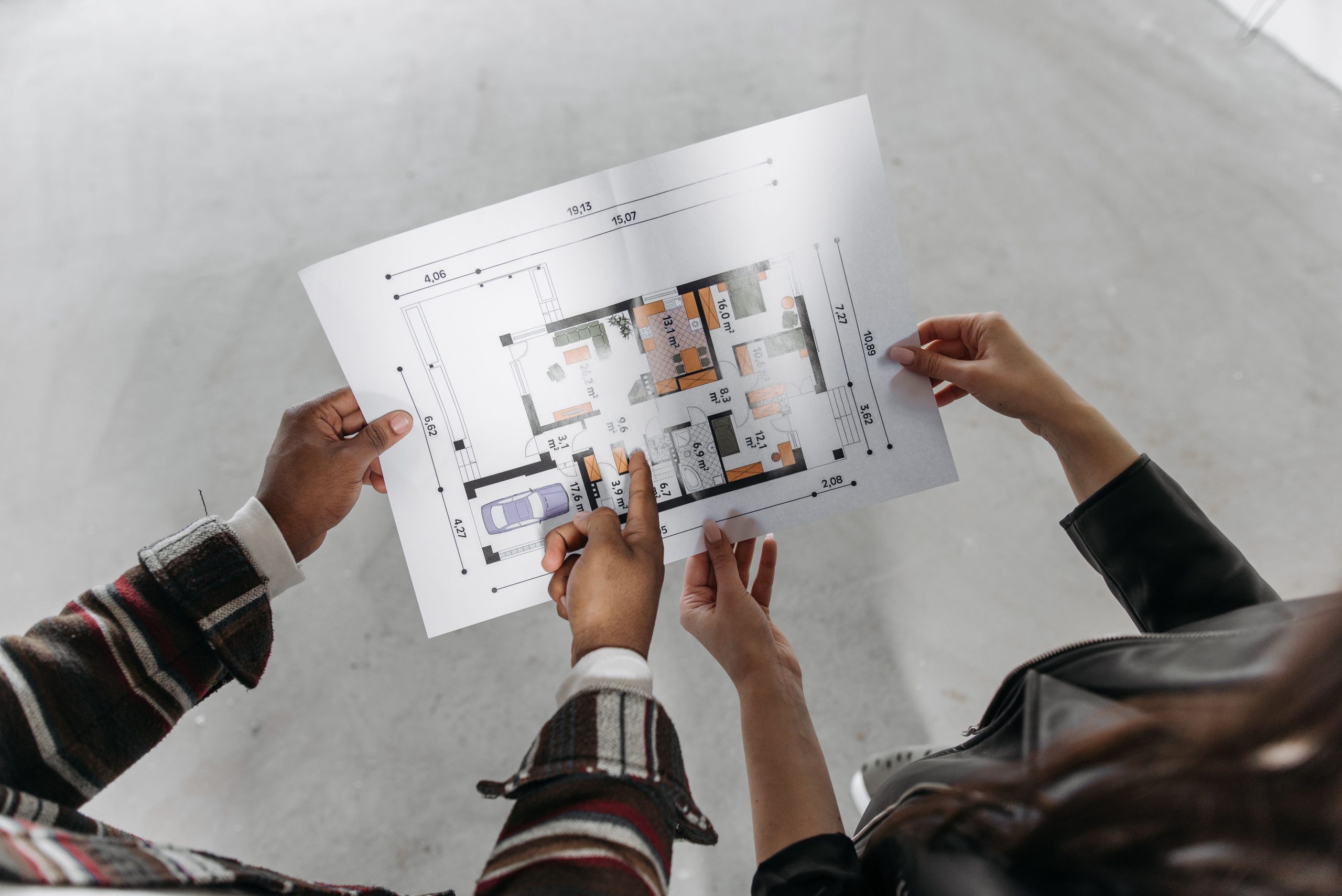 Two professionals reviewing a detailed architectural floor plan blueprint, representing strategic planning and business innovation at Inline Consulting.
