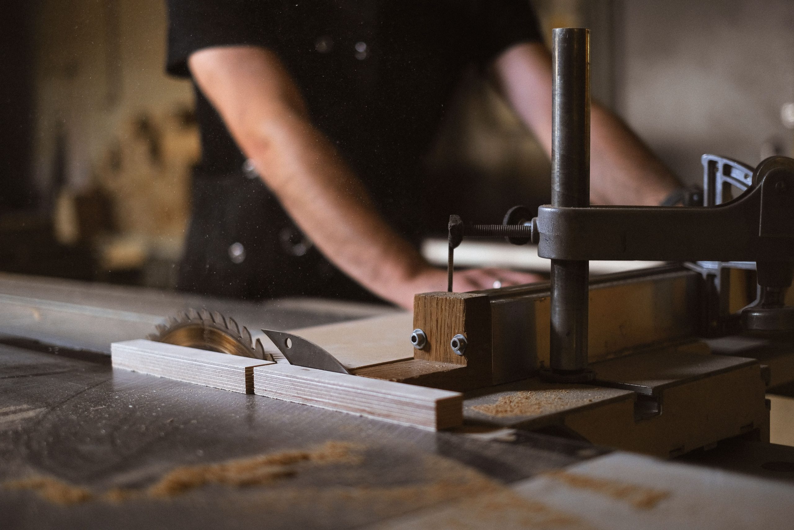 Precision cutting machine and circular saw blade in a workshop showcasing joinery manufacturing technology.